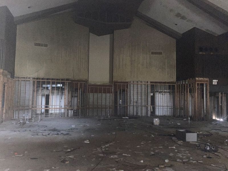 Interior of room with area previously used as an altar with debris on the floor